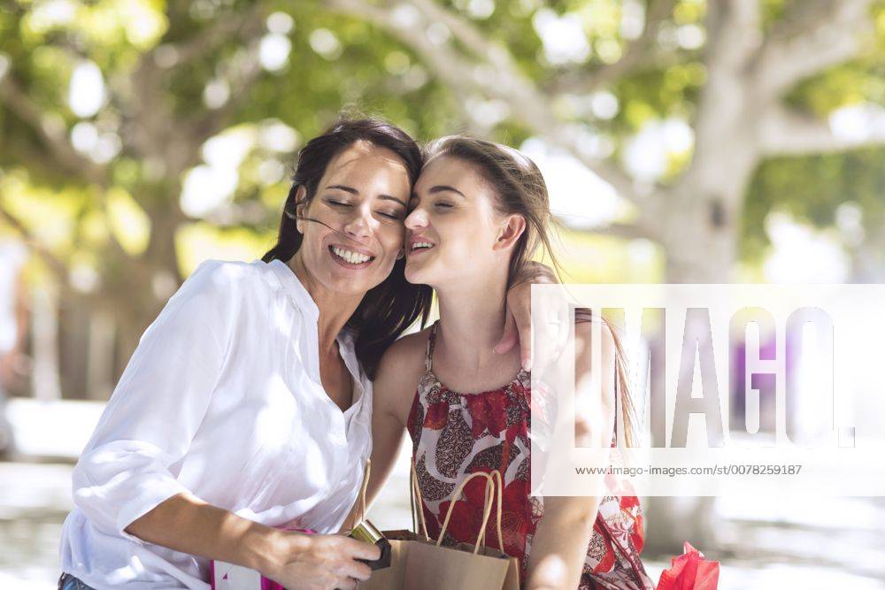 Happy mother and daughter with shopping bags embracing in the city model released Symbolfoto ZEF13402