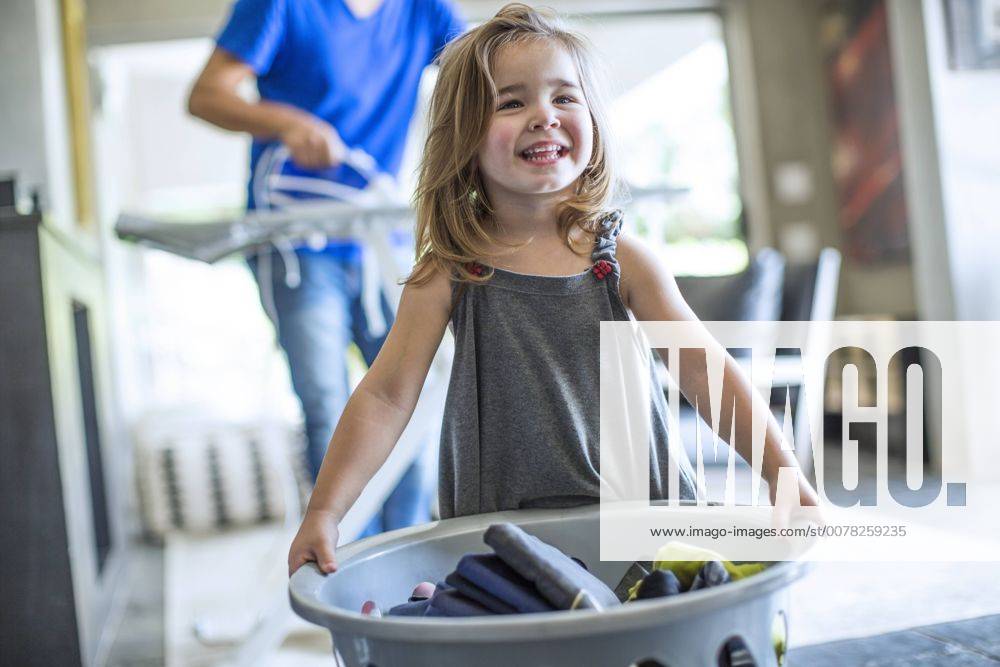 Happy baby girl holding laundry basket model released Symbolfoto property released ZEF13443
