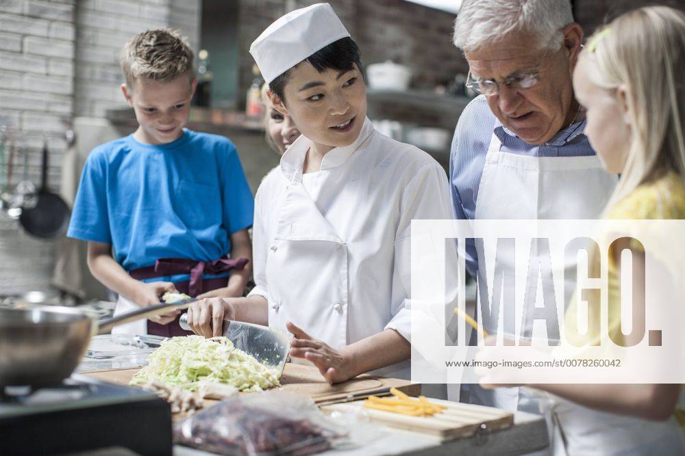 Female chef instructing kids in cooking class model released Symbolfoto property released ZEF13526