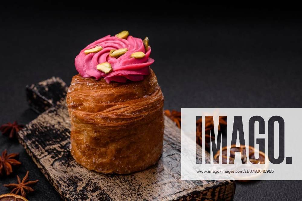 Sweet craffin or panettone garnished with raspberry and pistachio flavored cream, Sweet craffin or panettone garnished with raspberry and pistachio flavored cream on a dark concrete background, Sweet craffin or panettone garnished with raspberry and pistachio flavored cream on a dark concrete background, 17.10.2024,