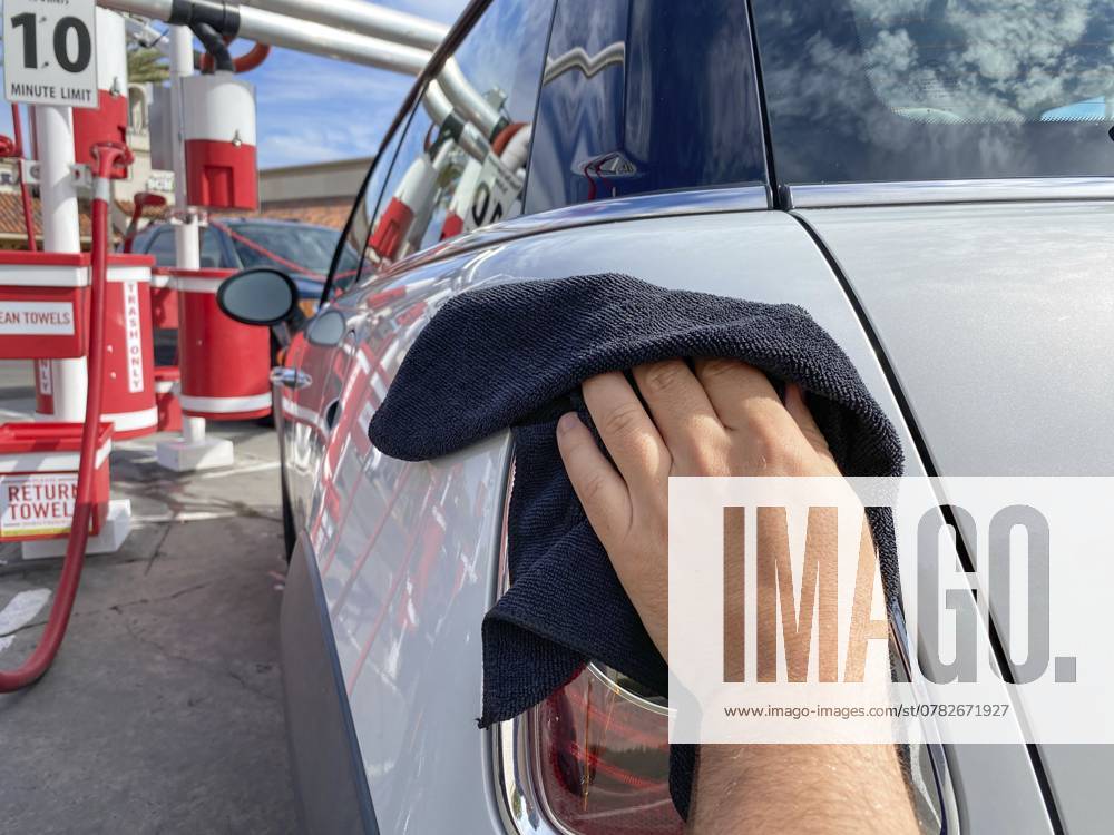 Männerhand beim Reinigen des Autos mit schwarzem Mikrofasertuch. Hand abwischen Oberfläche des Autos. Car Detailing und Autowäsche Konzept, San Diego, USA, 13. August 2020, Nordamerika Man s hand cleaning the car with black microfiber cloth. Hand wipe down surface of car. Car detailing and car wash concept, San Diego, USA, August 13th, 2020, North America