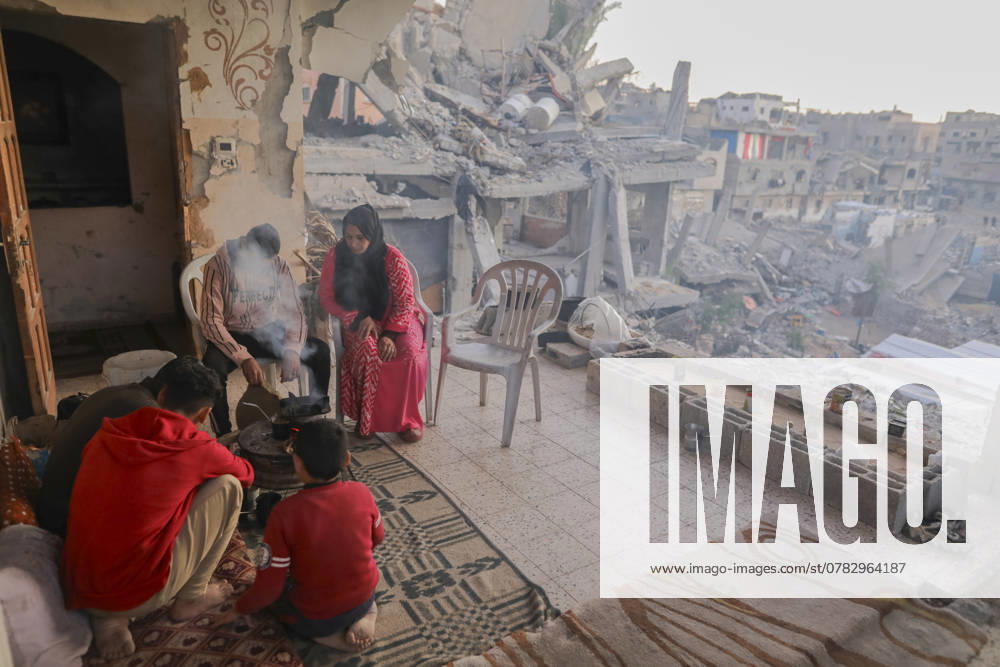 Israeli Palestinian conflict A Palestinian family sits amidst the rubble of their destroyed home, sharing a meal in Khan Younis, Gaza Strip, on December 3, 2024. Many displaced families struggle to access food and basic necessities. Gaza Gaza Strip Palestinian territories