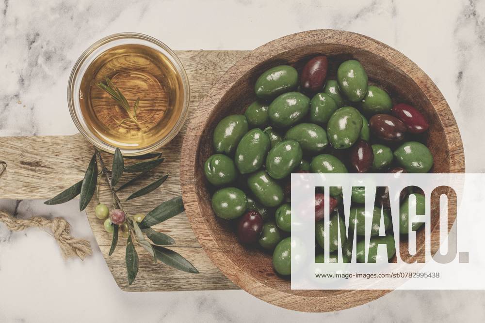 Chalkidiki Oliven, klassische griechische grüne Oliven, in einer Schale auf einem Schneidebrett, Draufsicht, ohne Personen Chalkidiki olives, classic Greek green olives, in a bowl on a cutting board, top view, without people
