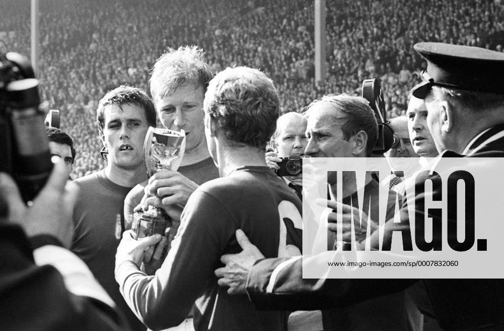 Fußball, WM 1966, Finale in Wembley, England - Deutschland 4-2 n.V. Bobby Moore (6) mit dem Coupe Jules Rimet nach dem Sieg im Finale der WM 1966, daneben v.li.: Geoff Hurst, Jack Charlton und Bobby Charlton (alle England) Jubel, Freude Sieg Weltmeister Siegerehrung Nationaltrikot Fotograf, Sportfotograf