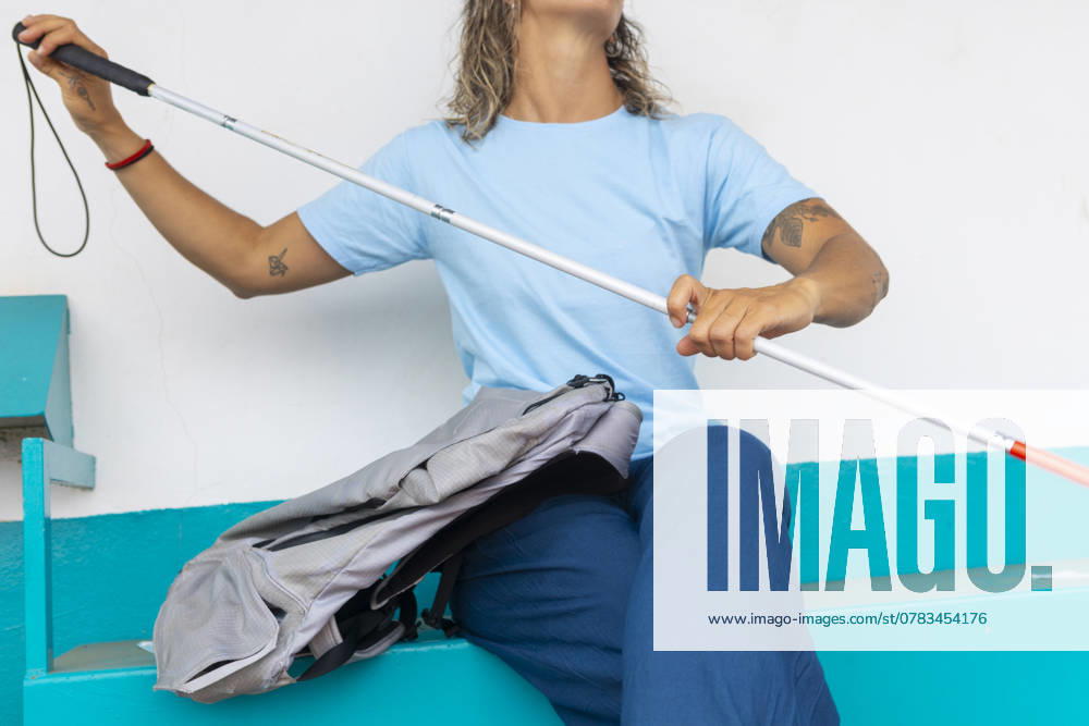 A woman confidently navigates her environment using a white cane Her determination and adaptability in daily tasks highlight resilience despite hearing and sight challenges Model Released JuanAizpuru_ID25147_727808_016