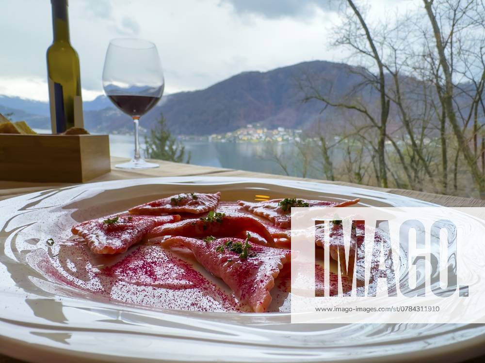 Restauranttisch mit Rote Bete Ravioli auf einem weißen Teller mit Bergblick in der Schweiz Restaurant Table with Beetroot Ravioli on a White Plate with Mountain View in Switzerland.