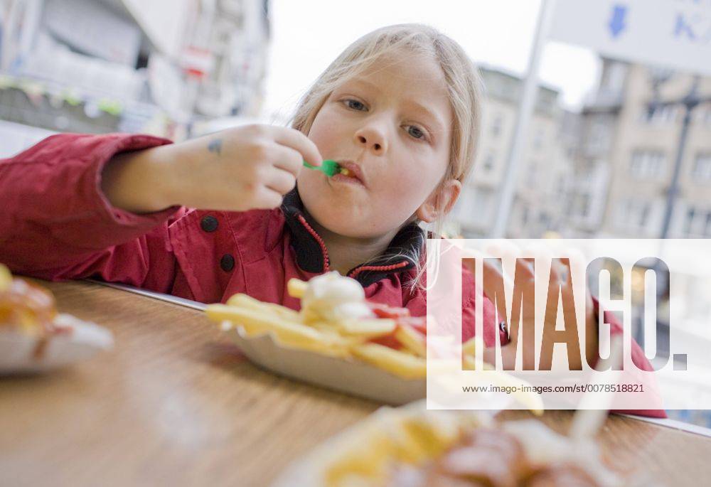 Ein Maedchen isst Pommes Frites . Bonn , Deutschland . A girl is eating french fries. Bonn , Germany . 06.12.2008 , MODEL RELEASE vorhanden , MODEL RELEASED , Bonn Deutschland