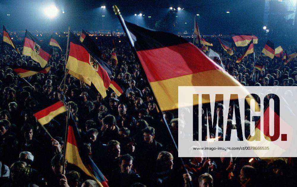 Menschen feiern die Deutsche Wiedervereinigung, dabei schwenken sie deutsche Flaggen und Fahnen Berlin, 03.10.1990, Â Berlin Deutschland