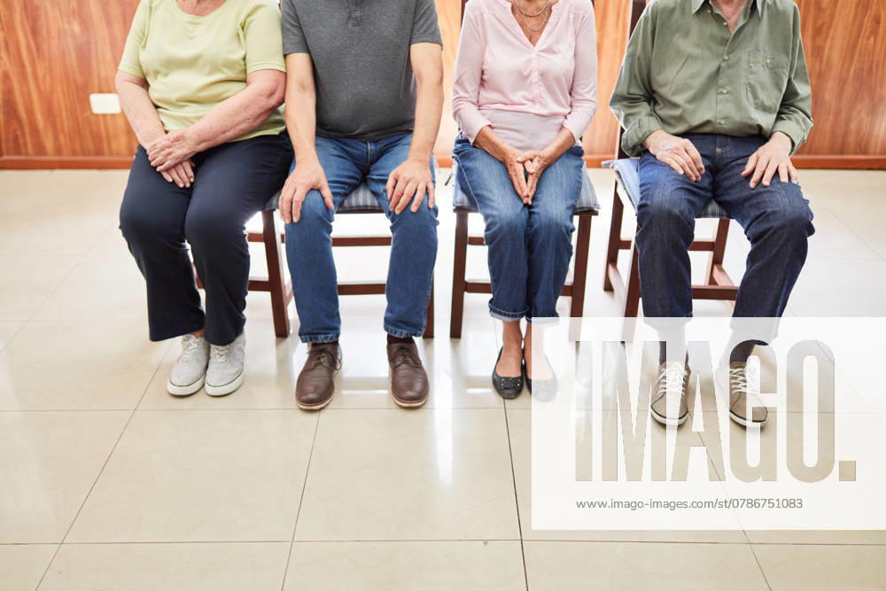 Gruppe Senioren sitzt auf Stühlen im Wartezimmer als Konzept für Wartezeit beim Arzt ,model released, Symbolfoto ,property released