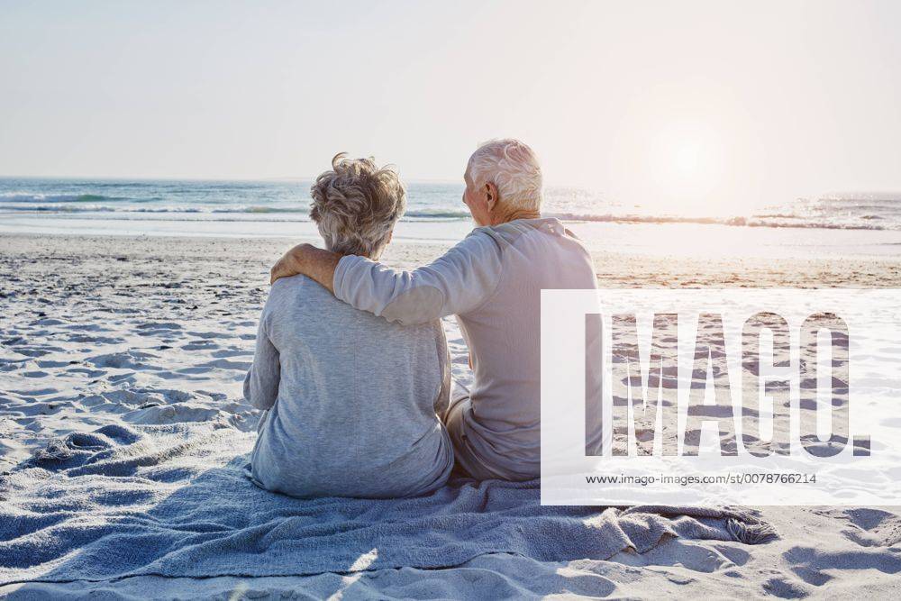 Senior couple sitting on the beach looking at distance model released Symbolfoto RORF00799