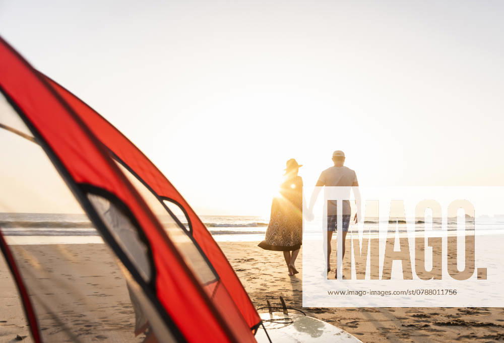 Romantic couple camping on the beach, doing a beach stroll at sunset model released, Symbolfoto, UUF15152