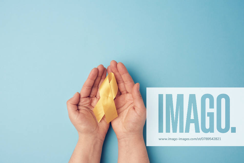 Two female hands hold in their palms a yellow ribbon in the form of a loop on a blue background, symbol of the fight against the cat s tumor, problem of suicides and their prevention, close up , 30553388.jpg, adult, awareness, blue, bone, campaign, cancer, care, closeup, concept, day, depression, diagnosis, endometriosis, examination, gold, hand, health, holding, hope, hospital, illness, insurance, female, woman, medical, medicine, oncology, osteosarcoma, person, pray, prevention, protection, ribbon, sarcoma, sign, skeleton, stethoscope, suicide, support, survive, symbol, symbolic, syndrome, yellow, RECORD DATE NOT STATED