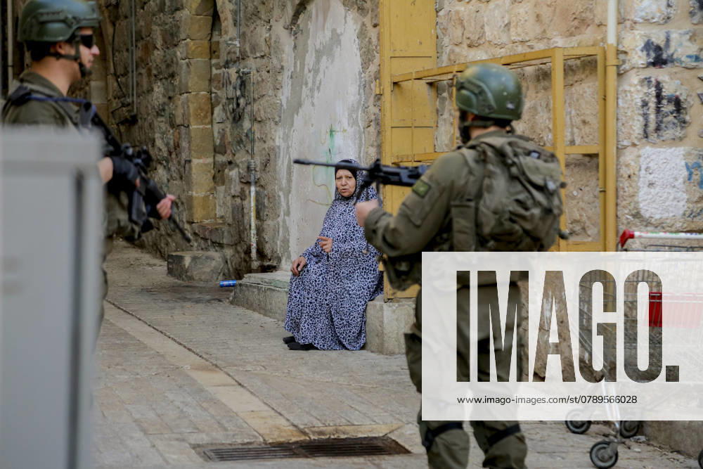 Israeli Security Measures in Hebron Old City A Palestinian woman talks to Israeli army soldiers standing guard as Israeli Jewish settlers tour the old market in the city of Hebron in the occupied West Bank on December 28, 2024. Hebron West Bank Palestinian territories