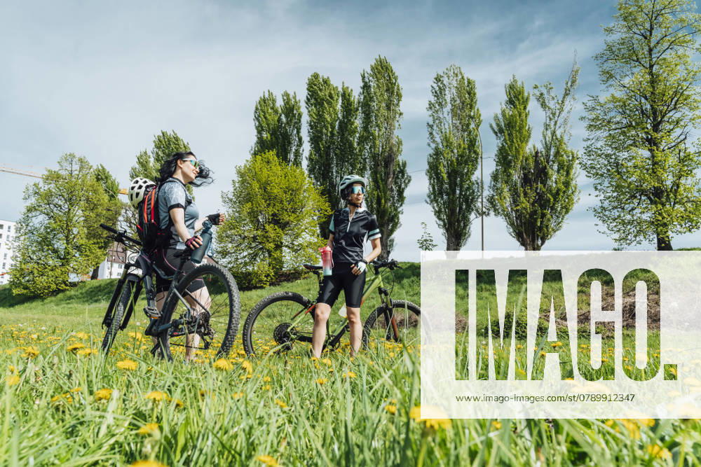 Sport friends standing near cycle at meadow model released, Symbolfoto, OSF02650