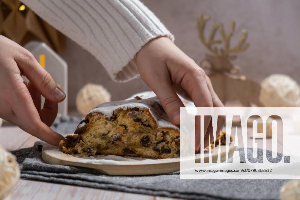 Weibliche Hand, die ein Stück von hausgemachten Weihnachten traditionellen Kuchen Kuchen mit Marzipan Nüsse und getrocknete Früchte Gebäck Dessert Stollen. Winterferien Saison Atmosphäre. Köstliche leckere Zusammensetzung nach Hause Tischeinstellung Weibliche Hand, die ein Stück von hausgemachten Weihnachten traditionellen Kuchen Kuchen mit Marzipan Nüsse und getrocknete Früchte Gebäck Dessert Stollen. Winterferien Saison Atmosphäre. Köstliche leckere Zusammensetzung nach Hause Tischeinstellung