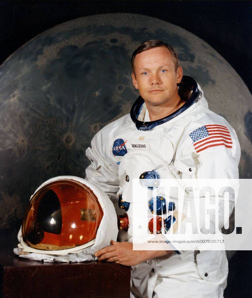 Portrait of Astronaut Neil A. Armstrong, commander of the Apollo 11 Lunar Landing mission in his space suit, with his helmet on the table in front of him. Behind him is a large photograph of the lunar surface.July 1, 1969 Hollywood CA USA 1003_201