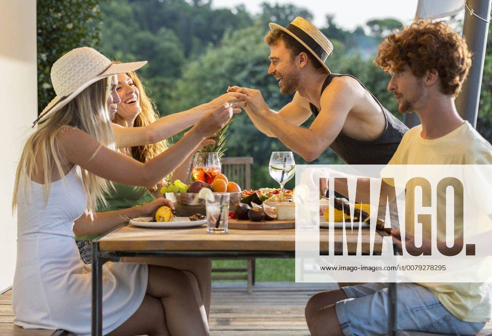 Happy friends having dinner at outdoor table model released Symbolfoto property released ZOCF00325