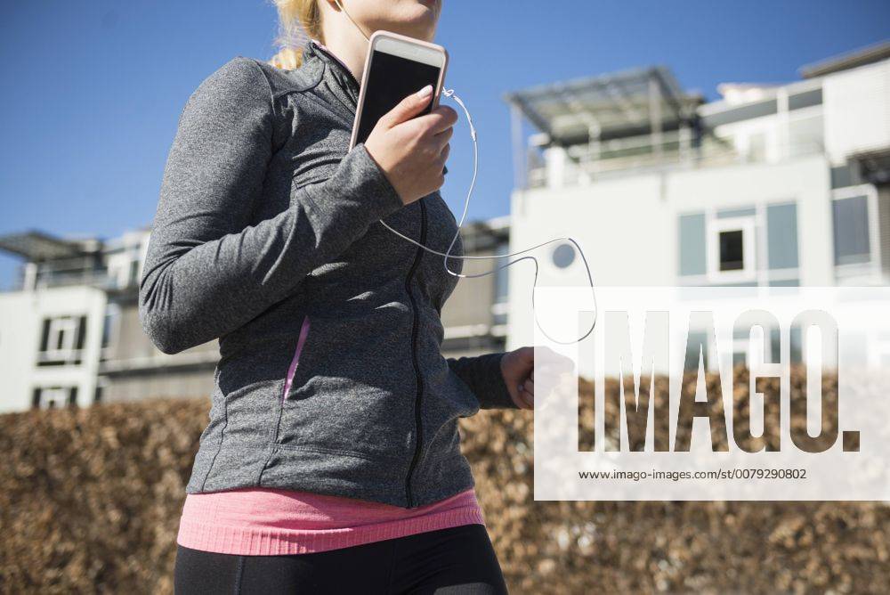 Woman jogging and listening music on smart phone mit_2032_10900