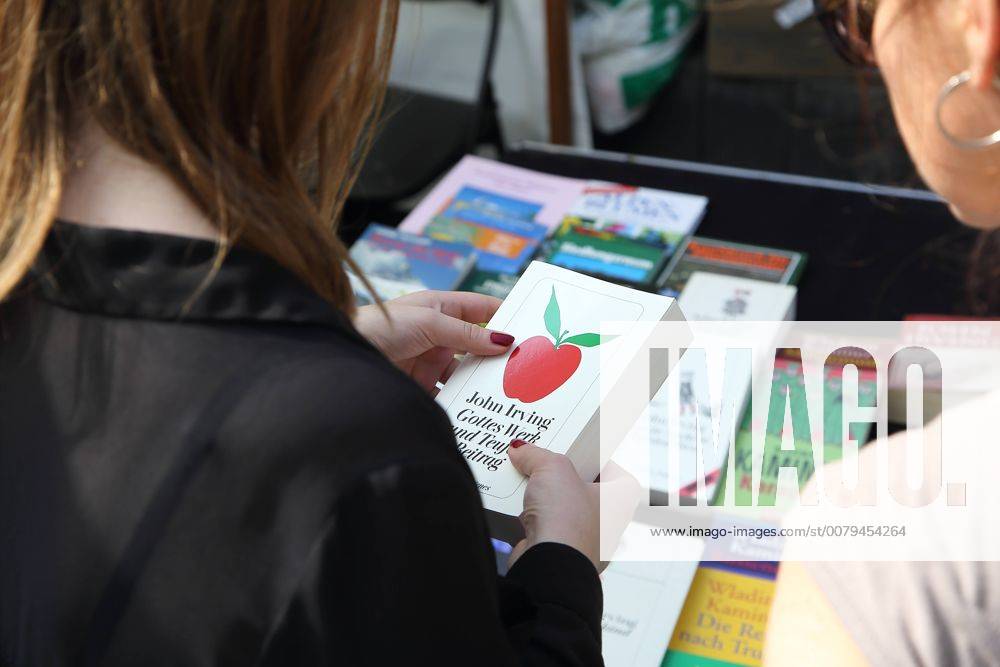 Frauen betrachten das Buch Gottes Werk und Teufels Beitrag von John Irving auf dem Büchermarkt in der Schiffbauergasse während des Literaturfestivals in Potsdam, 9. Juli 2017. LIT:potsdam Büchermarkt