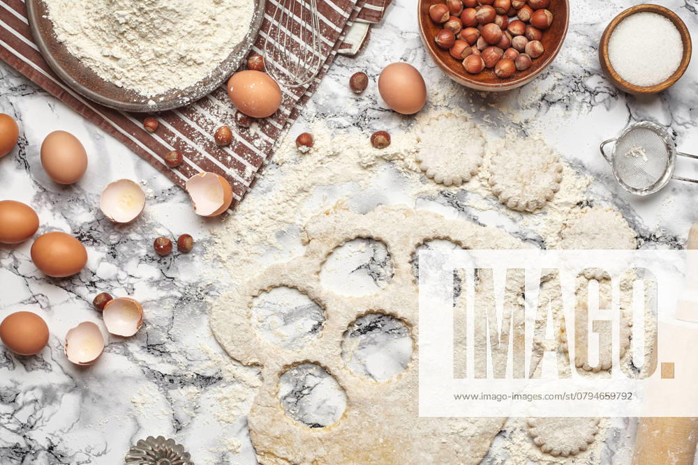 Close-up shot. Top view of a kitchenware and baking ingredients on a marble table background. There are some eggs and an eggshell, flour on a brown striped apron, sieve, sugar, scattered hazelnuts, rolling pin, billet for cookies, cupcake mold, rolled dough on a table. , 47712946.jpg, flour, table, background, cooking, food, kitchen, pastry, preparation, white, egg, butter, top, above, bake, dough, homemade, utensils, cake, basic, easter, meal, product, sieve, rolling pin, view, recipe, cupcake, mold, ingredient, milk, wooden, brown, traditional, decoration, rustic, hazelnuts, sweet, dessert, menu, pie, preparing, christmas, utensil, powdered, close-up, nobody, domestic, striped, apron, billet RECORD DATE NOT STATED