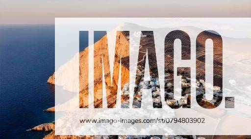 Aerial view of a coastal village with white buildings and a mountain in Folegandros, Greece during sunset 25268872 RECORD DATE NOT STATED
