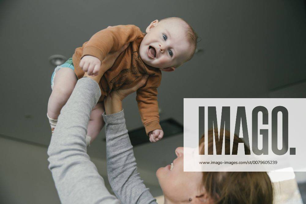 Grandmother lifting up baby at home model released Symbolfoto property released MFF03679