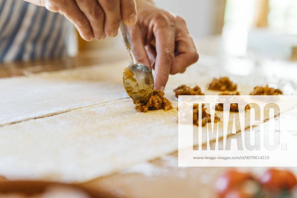 Woman s hands putting ravioli stuffing on dough model released Symbolfoto property released JRFF01402