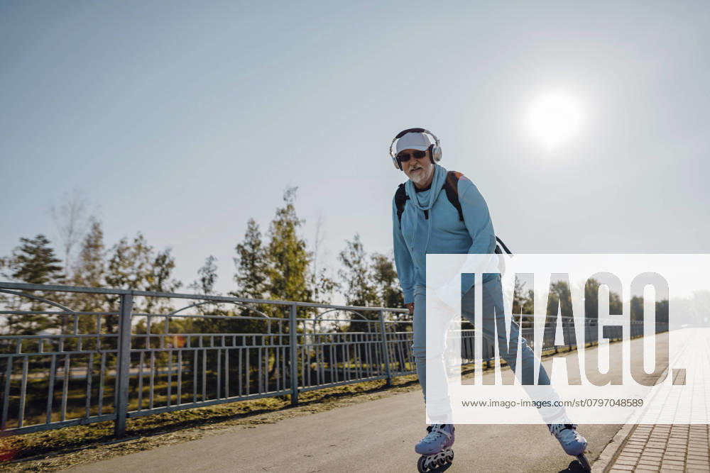 Cheerful senior man riding roller skates in park model released, Symbolfoto, IEF00796
