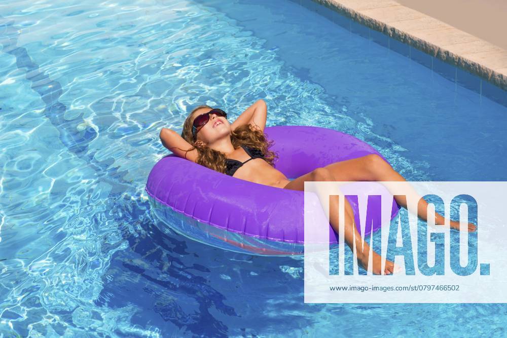 Bikini Kinder Mädchen mit Sonnenbrille entspannt auf lila aufblasbaren Pool Ring Bikini children girl with sunglasses relaxed on purple inflatable pool ring