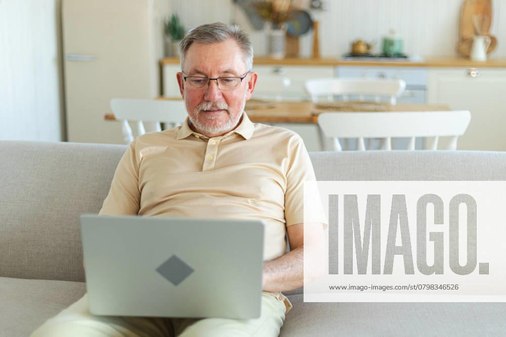 Zuversichtlich, stilvoll glücklich mittleren Alters Senior Mann mit Laptop zu Hause. Stilvolle ältere reifen 60er Jahre Bart Großvater sitzt auf der Couch Blick auf Computer-Bildschirm Tippen Chatten Lesen Schreiben von E-Mail. Zuversichtlich, stilvoll glücklich mittleren Alters Senior Mann mit Laptop zu Hause. Stilvolle ältere reifen 60er Jahre Bart Großvater sitzt auf der Couch Blick auf Computer-Bildschirm Tippen Chatten Lesen Schreiben von E-Mail. ,model released, Symbolfoto