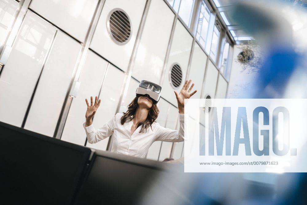 Businesswoman using VR goggles in office model released Symbolfoto property released KNSF02040