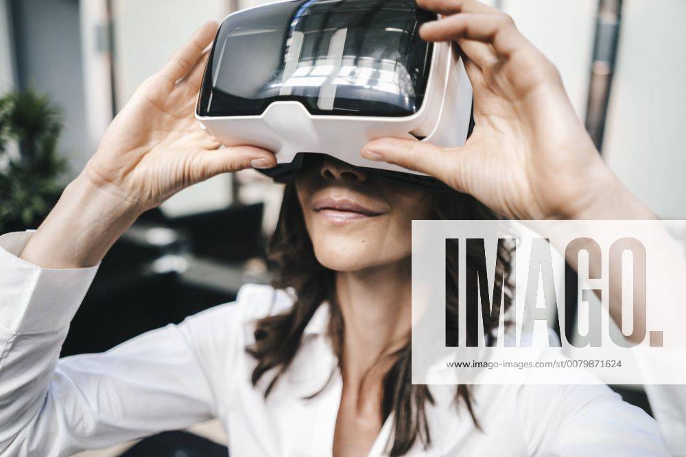 Businesswoman using VR goggles in office model released Symbolfoto property released KNSF02041