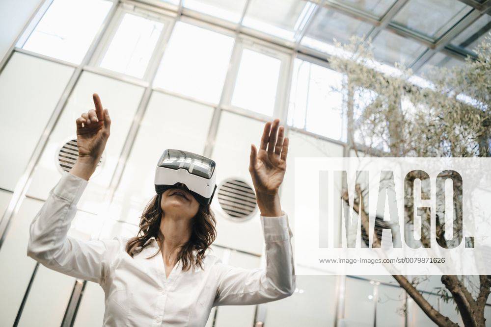 Businesswoman using VR goggles in office model released Symbolfoto property released KNSF02043