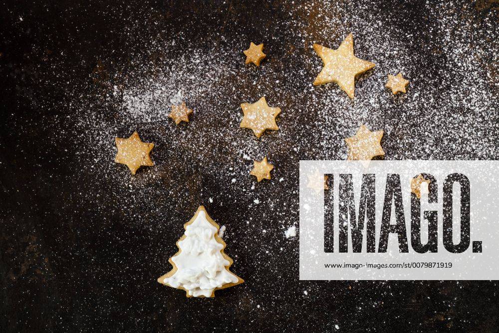 Christmas Cookies and icing sugar on baking tray SBDF03272
