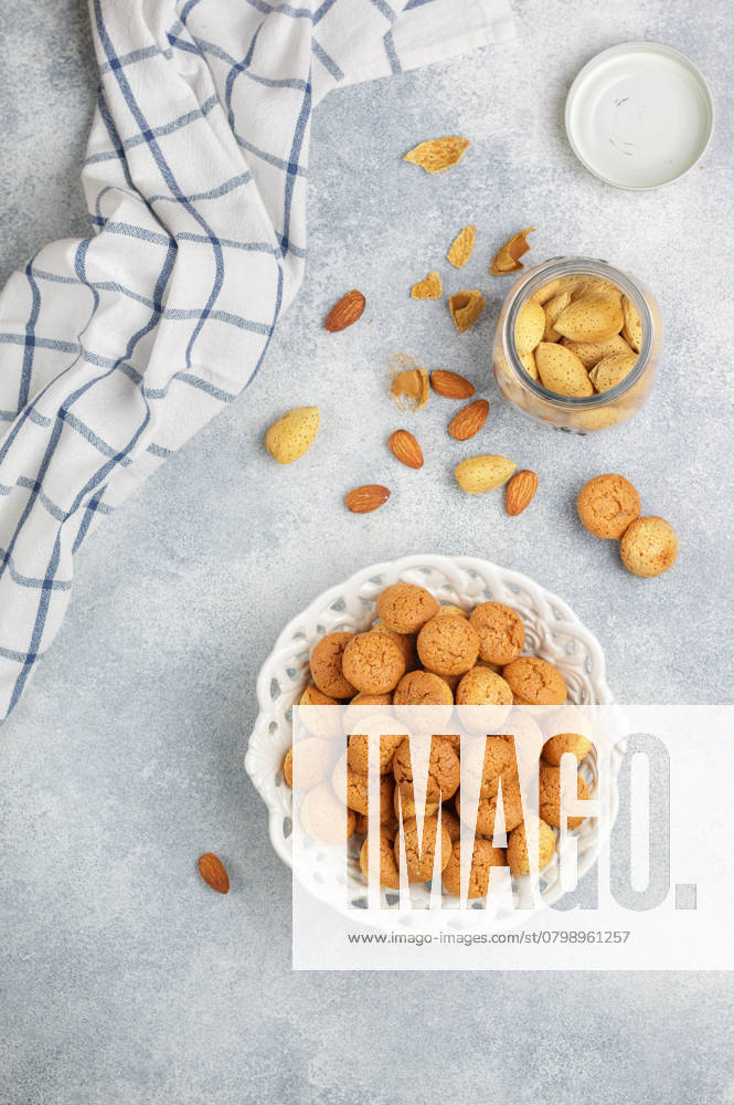 Amaretti - traditionelles italienisches Mandelgebäck in einem weißen Teller auf grauem Betonhintergrund von oben. Amarettini-Kekse. Selektiver Fokus, Kopierbereich Amaretti-traditional Italian almond cookies in a white plate on a gray concrete background top view. Amarettini biscuits. Selective focus, copy space