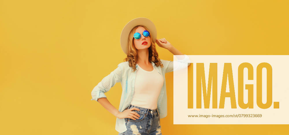 Sommer Porträt der stilvollen jungen Frau posiert in Hut, Brille, Hemd auf hellen gelben Hintergrund Summer portrait of stylish modern young woman posing in straw hat, glasses, shirt on bright yellow studio background ,model released, Symbolfoto