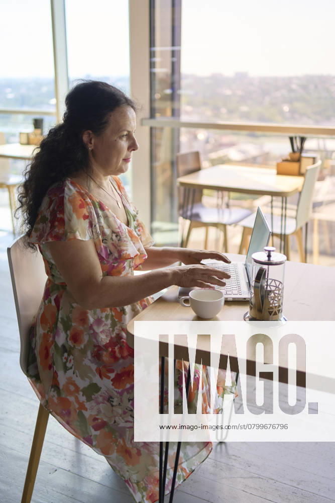 A 60s woman drinking nettle tea in modern coworking office during lunch break Model Released VictoriaAntre_ID25251_730421_030