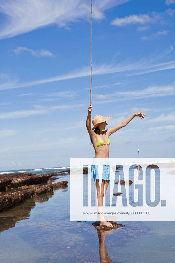 Young woman caught a fish while fishing with rod at the sea A5