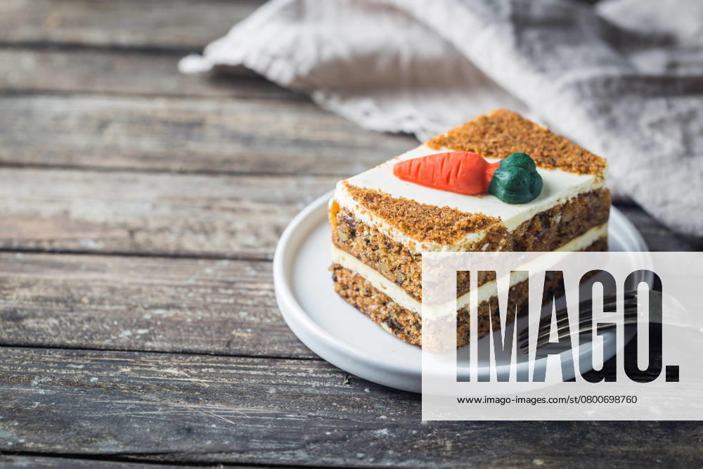 Scheibe Karottenkuchen Slice of carrot cake with cream cheese frosting on wooden table