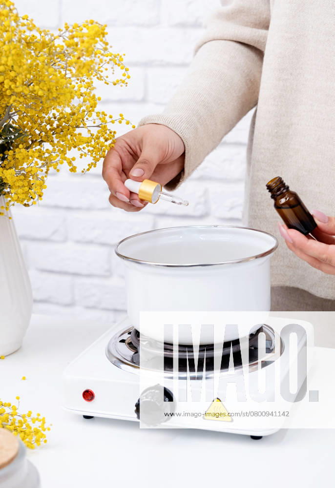 Creative hobby at home. Woman making decorative aroma candle at table, adding aroma oil , 50230606.jpg, candle, wax, home, person, making, woman, female, background, aroma, craft, handmade, creative, closeup, workshop, diy, hobby, crafting, homemade, wick, table, glass, white, aromatic, work, process, scent, made, candles, stove, cozy, paraffin, essential, art, style, decorative, produce, adult, melted, interior, hand, decoration, equipment, natural, floral, preparation, scented, ingredients, hands, decor, simple RECORD DATE NOT STATED