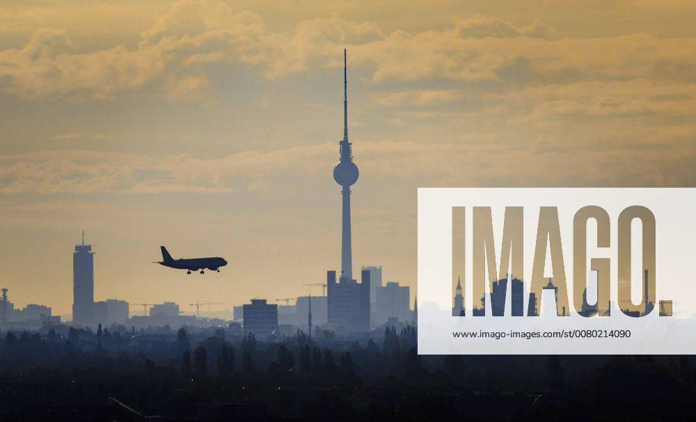 A plane flies in the morning in the landing approach to the airport Tegel to Berlin television tower Berlin 22 09 2017 Berlin Germany