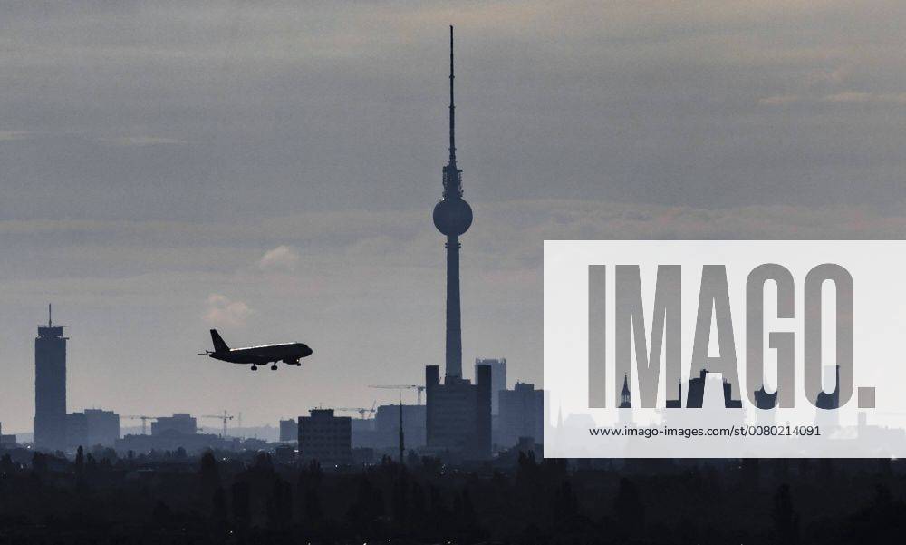 A plane flies in the morning in the landing approach to the airport Tegel to Berlin television tower Berlin 22 09 2017 Berlin Germany