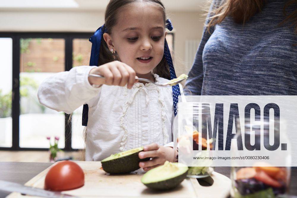 Portrait of little girl preparing healthy salad with her mother in the kitchen model released Symbolfoto property released IGGF00003
