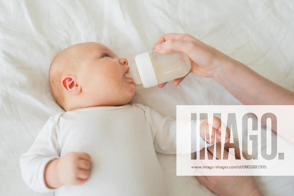 Glückliche Familie zu Hause. Mutter Hand Pflege Fütterung kleines Baby Kleinkind Kind Milch aus der Flasche. Newborn Infant Baby Mädchen saugen Essen trinken Milch. Mutter der Brust Fütterung Baby. Mutterschaft glückliches Kind. Glückliche Familie zu Hause. Mutter Hand Pflege Fütterung kleines Baby Kleinkind Kind Milch aus der Flasche. Newborn Infant Baby Mädchen saugen Essen trinken Milch. Mutter der Brust Fütterung Baby. Mutterschaft glückliches Kind. ,model released, Symbolfoto