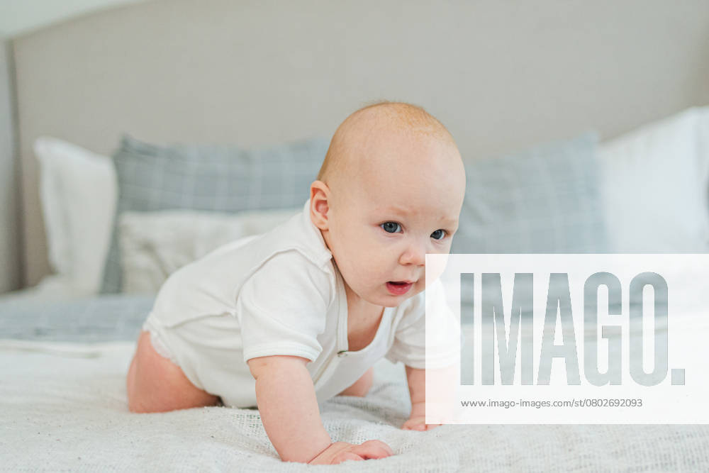 Glückliches Baby. Nettes kleines neugeborenes Mädchen mit lächelndem Gesicht krabbelt auf dem Bett im Schlafzimmer. Infant Baby ruht spielen liegend auf Decke zu Hause. Mutterschaft glückliches Kind Kinderbetreuung Konzept. Happy baby. Cute little newborn girl with smiling face crawling on bed in bedroom. Infant baby resting playing lying down on blanket at home. Motherhood happy child childcare concept ,model released, Symbolfoto