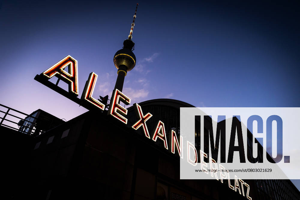 Evening atmosphere in Berlin The illuminated lettering at Alexanderplatz S station as dusk falls The television tower, popularly known as the Telespargel, can be seen above in the Berlin evening sky Berlin Alexanderplatz Berlin Germany