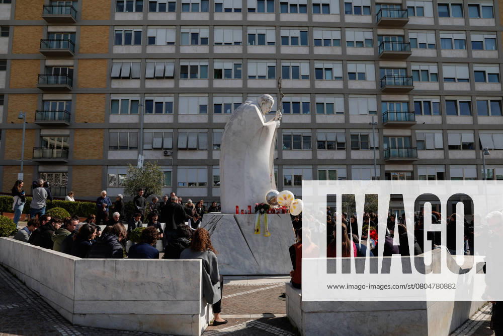 People pray under the statue of late Pope John Paul II outside Agostino Gemelli Hospital where Pope Francis is hospitalized to continues his treatments for bilateral pneumonia, in Rome, Italy, 23 February 2025. ANSA GIUSEPPE LAMI Roma Italia - ZUMAa110 20250223_zaf_a110_006