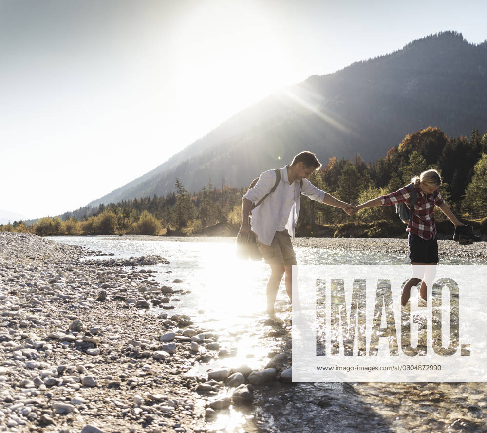 Austria, Alps, couple on a hiking trip wading in a brook model released, Symbolfoto, UUF16533