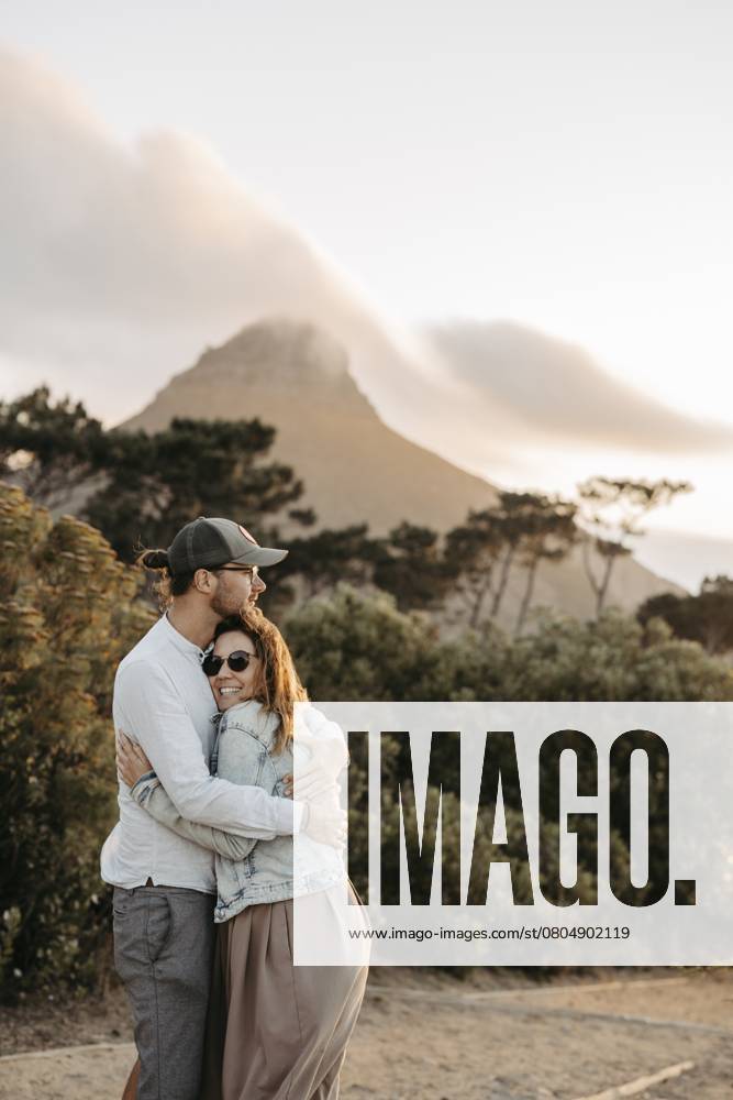 Paar steht bei Sonnenuntergang vor dem Signal Hill, Kapstadt, Südafrika Couple standing in front of Signal Hill at sunset, Cape Town, South Africa, Africa
