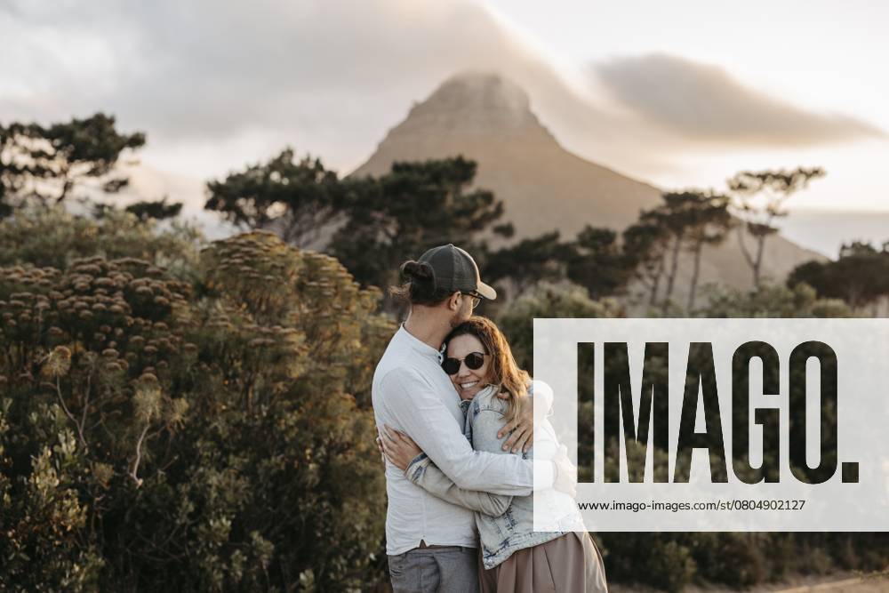Paar steht bei Sonnenuntergang vor dem Signal Hill, Kapstadt, Südafrika Couple standing in front of Signal Hill at sunset, Cape Town, South Africa, Africa